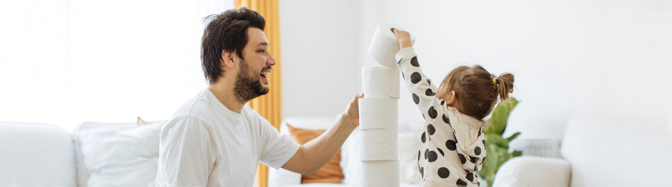 Father and daughter are building a tower of toilet paper rolls